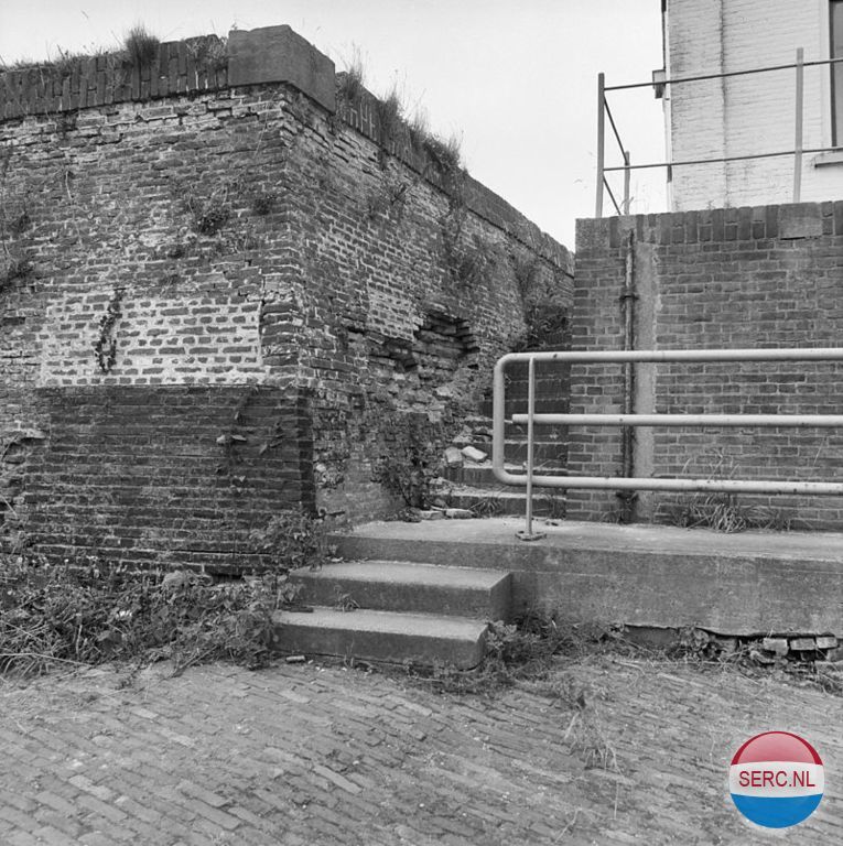Gorinchem: De muur van de Kleine Merwedesluis in 1982 die wel wat restauratie behoeft. De Kleine Merwedesluis was een schutsluis tussen de Lingehaven van Gorinchem en de Merwede. De sluis is vervangen door de Lingesluis op dezelfde plaats. De bijbehorende voormalige brugwachterswoning werd gebouwd in 1910 naar een neorenaissance-ontwerp van A.A.H.W. König. De woning bevat een gevelsteen uit 1640. De sluis werd ook wel Oude Merwedesluis genoemd, dit ter onderscheiding van de veel later gebouwde Grote Merwedesluis tussen het Merwedekanaal en de Merwede die ook wel als Nieuwe Merwedesluis bekend staat .