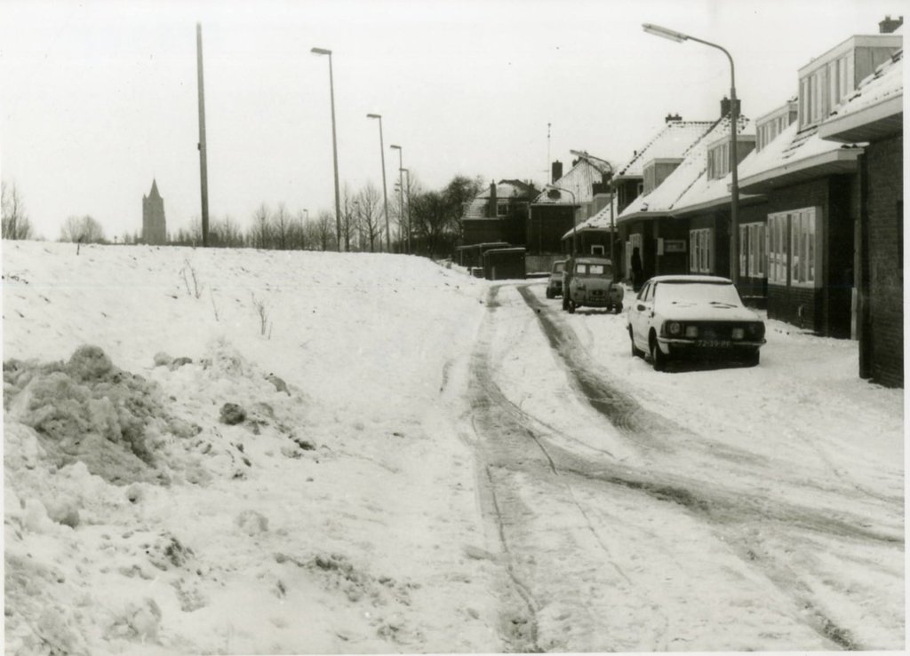 Een behoorlijke laag sneeuw bedekt het talud van de Wolpherensedijk, de straat en huizen van de Steenenhoeksestraat op het Eerste West in 1977