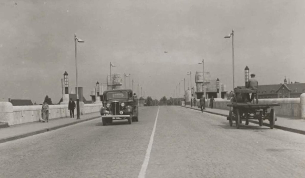 De oude Wilhelminabrug in de jaren '30. Rechts op de foto net net het gebouw waar nu (2017) Kumulus is gevestigd.In 1930 startte de bouw van de brug en op 18 april 1932 opende de brug voor het verkeer. Op 10 mei 1940 werd de brug opgeblazen in opdracht v