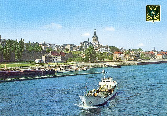 Waalkade Nijmegen: Een coaster vaart richting verkeersbrug met op de achtergrond De Waalkade en de contouren van de stad
