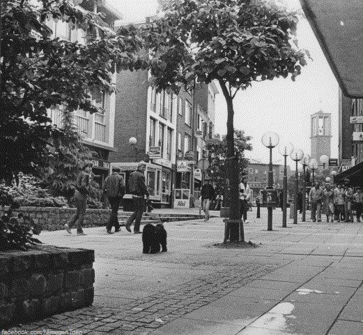 Nijmegen 1989: Een voor velen zeer herkenbare foto van de Houtstraat omstreeks het jaar 1989. We kijken ongeveer vanaf de plek van antiquariaat van Hoorn in de richting van Plein 1944. Rechts de inmiddels niet meer bestaande Centrum bioscoop waar volgens de belettering de film 'Star Trek' te zien is. Links van het midden zien we cafetaria 'De Gouden Haan' (voorheen Mini Resto 'Kangeroe') en daarnaast het bekende Café Biljart Samson. Op de achtergrond zijn de kerk in de Molenstraat en delen van Plein 1944 nog te zien.
