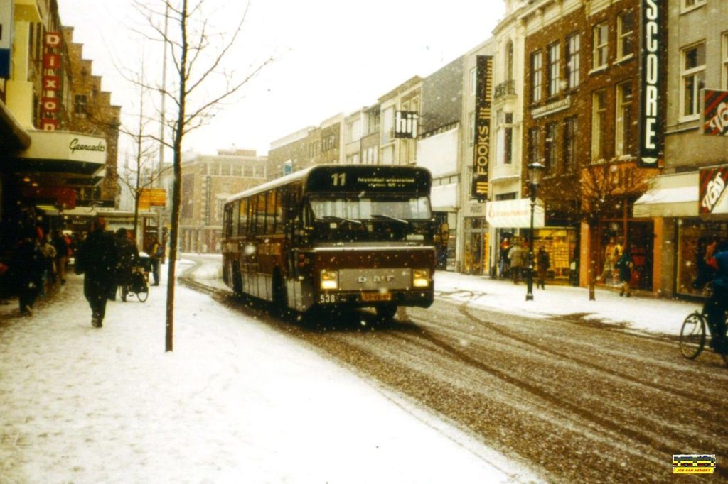 Nijmegen 1991: Een besneeuwde Burchtstraat in het begin van de jaren '90. Lijn 11 (DAF Hainje 538) van de CVD naar Heyendaal/Universiteit doet zijn ronde. Veel winkels van toen zijn inmiddels verdwenen, enkele zijn er, bijna 25 jaar later nog steeds zoals Dixons en Hij (Inmiddels WE geheten).