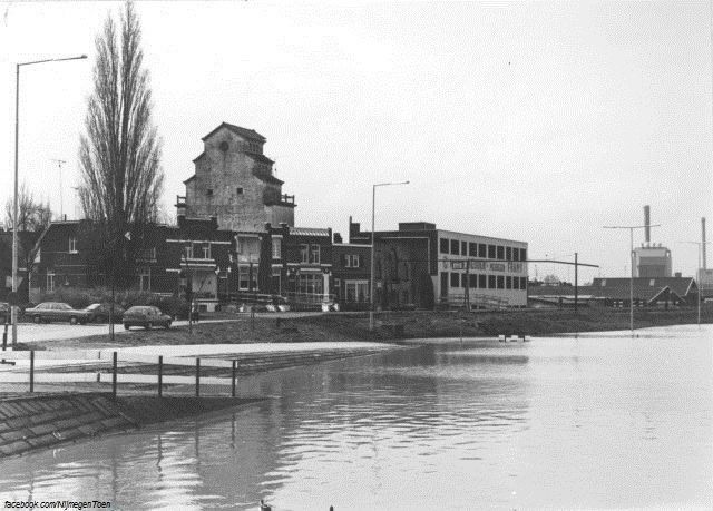 Nijmegen 1988: We kijken aan het eind van de jaren'80 vanuit de Voorstadslaan op de Havenweg tijdens hoogwater. Op de achtergrond zien we nog het magazijn van Framy Meubelen. De Waalhaven is ook wel bekend als de Nieuwe Haven. De haven is gelegen aan de Waal net voorbij de Nieuwe Hezelpoort en direct naast de Spoorbrug. De haven werd in 1852 en 1853 aangelegd als vervanger van de Oude Haven, die ter hoogte van het midden van de huidige Waalkade gelegen was en was een industriehaven.Die functie had de haven tot midden jaren '90 en sindsdien is het een vluchthaven en aanlegplaats voor de beroepsvaart. Er liggen ook enkele woonboten. In de jaren '30 werd de haven in het kader van de werkverschaffing uitgebreid. Het beheer is in handen van de gemeentelijke havendienst. De haven is 380 meter lang en tussen de 95 en 200 meter breed. De diepte varieert tussen de 4,50 en 5,75 meter. Rondom de haven ligt wat verouderde industrie en het slachthuis. Dit moet in het kader van het stadvernieuwingsproject Koerswest plaatsmaken voor woningen onder de naam Waalfront. Ook de drukkerij en kantoren van De Gelderlander lagen tot 2011 direct aan de Waalhaven.