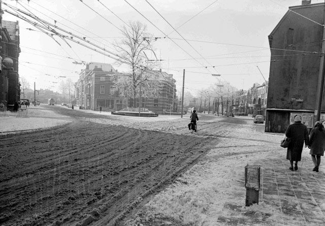 Nijmegen 1960: Een zeer sfeervolle foto van een besneeuwde Hertogstraat. We kijken in de richting van het Hertogplein met de Wilhelminaboom. Rechts Klein Mariënburg. Links de Van der Brugghenstraat.