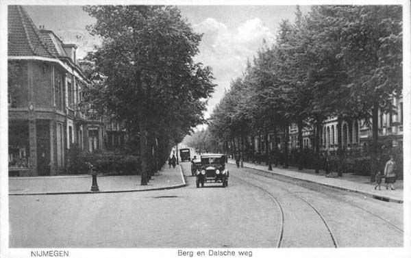 Nijmegen: Berg en Dalseweg gezien vanaf het Mariaplein in de jaren '30. | Het hoekpand links was van de Gruyter, in het huis met uitbouw woonde notaris Haffmans, achter de eerste auto een bakkerswagen waarschijnlijk van firma Oudvorst. Ter hoogte waar de twee mensen lopen cafe Wertha. Na de oorlog heeft hier een auto sloperij ingezeten, daarna de familie van Weel die de naam Trianon voerden.