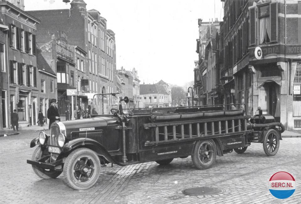 Nijmegen: De Hertogstraat 1935. Een brandweerwagen van het type Whippet Six met links achteraan ruimte voor verloopkoppelingen staat geparkeerd in de richting van de brandweerkazerne.