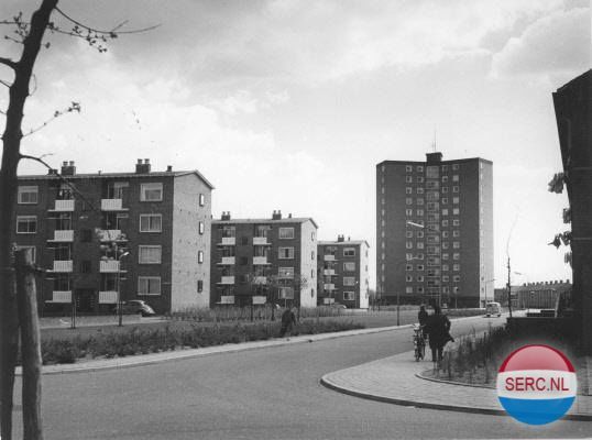 Nijmegen: Straatbeeld vanuit de Heidevenstraat richting Heidebloemstraat; links de flats aan de Koolwitjeshof, het Koningsmantelhof en de Pijlstaarthof. 1960