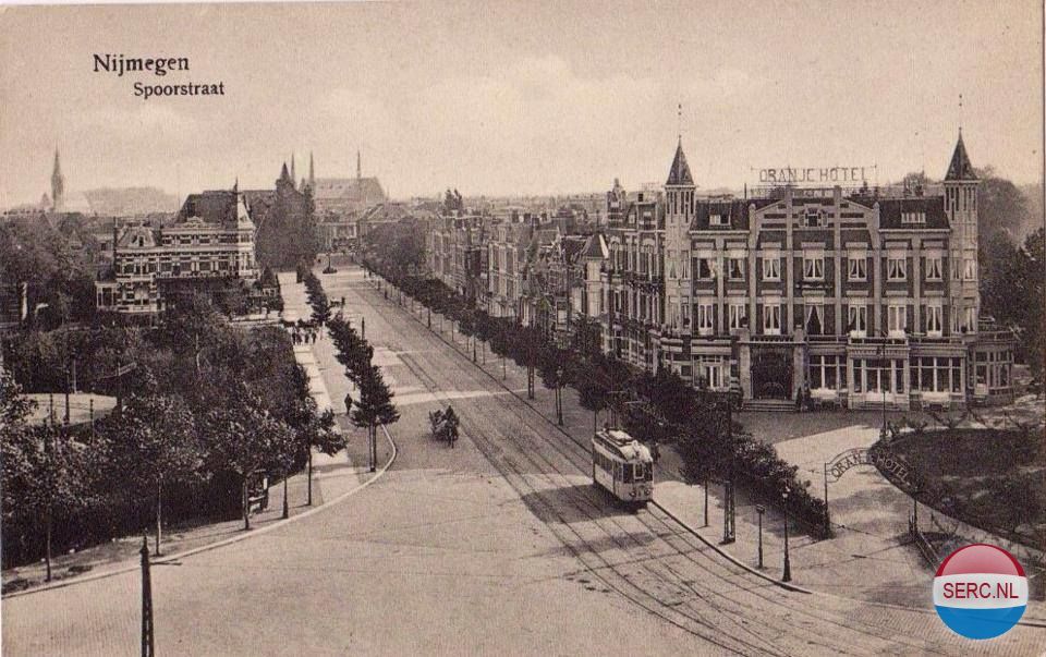 Nijmegen: De Spoorstraat met rechts Het Oranje Hotel en achter zichtbaar het Kolpinghuis, de oude Petrus Canisiuskerk in de Molenstraat en de oude St. Dominicuskerk in de Broerstraat. 1933