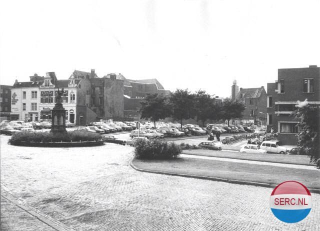 Nijmegen: Het Valkhofplein gezien vanuit het Valkhofpark. Links op de achtergrond de Hoogstraat. Rechts het Cultureel Centrum De Lindenberg op de hoek met de Ridderstraat. 1975