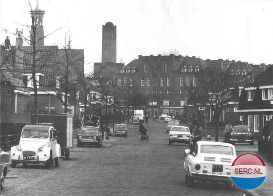 Nijmegen: De Sweelinckstraat in 1971. Gezien vanuit de Obrechtstraat. Op de achtergrond de Prins Hendrikkazerne met bijbehorende toren en links de toren van de Christus Koningkerk.