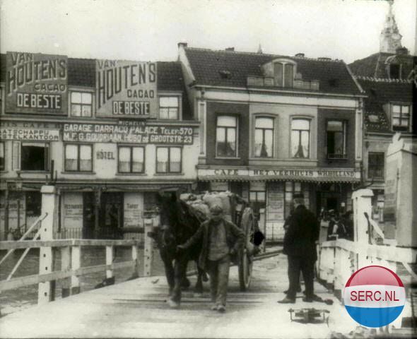 Nijmegen: De Waalkade in 1914. Met paard en wagen naar de gierpont De Zeldenrust. Genomen vanaf de pont richting zuiden met op de achtergrond café Het Veerhuis.
