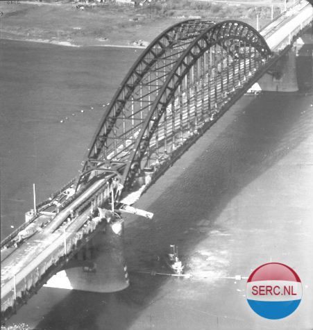 Nijmegen: De Waalbrug beschadigd en tijdelijk gerepareerd met een zogenaamde Baileybrug (deze zie je net voor de boog begint) in 1944
