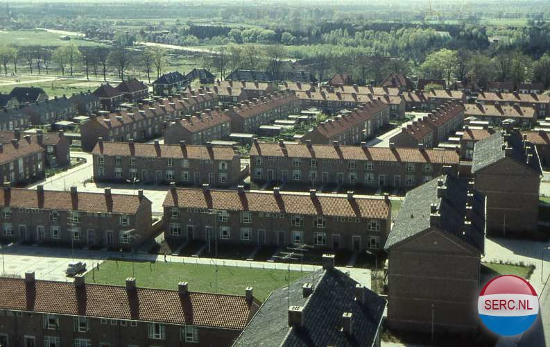 Nijmegen: Panorama van de Hetertse Hei omstreeks 1965. De drie flats rechts staan aan de Krekelstraat, die nog net in de hoek te zien is. Het grasveld links is de Moshommelhof. Achter de rijtjeswoningen met rode pannendaken staan de vrijstaande huizen aan de Nieuwe Mollenhutseweg