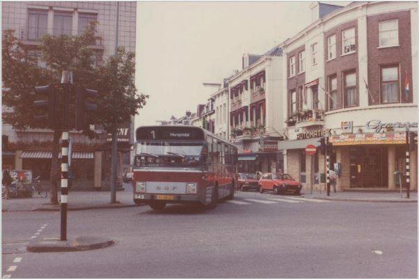 Lijn 1 naar Hengstdal draait in 1984 vanuit de In de Betouwstraat de Bisschop Hamerstraat in, richting het Keizer Karelplein. Het is alweer een tijd geleden dat de stadsbus van de CVD nog door de In de Betouwstraat reed. Rechts op de foto zien we Cafetaria Groenen waar de vlaggen al uithangen voor de naderende Vierdaagse en Zomerfeesten.