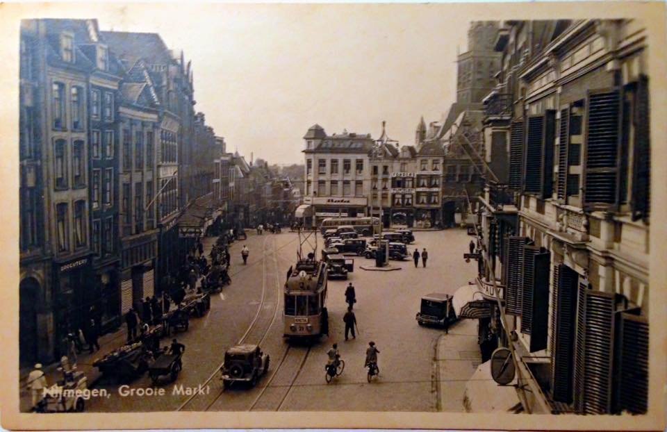 Levendig straatbeeld van de Grote Markt (toen nog geschreven als Groote Markt) omstreeks 1938. We zien links het grote pand van Vroom & Dreesmann en bovenin het helaas verdwenen pand van Bata. Links van Bata de Stikke Hezelstraat. Uiteraard ontbreekt de tram niet op deze ansichtkaart. Wie goed kijkt ziet links ook de marktkramen waar de kooplieden hun waar hebben uitgestald.