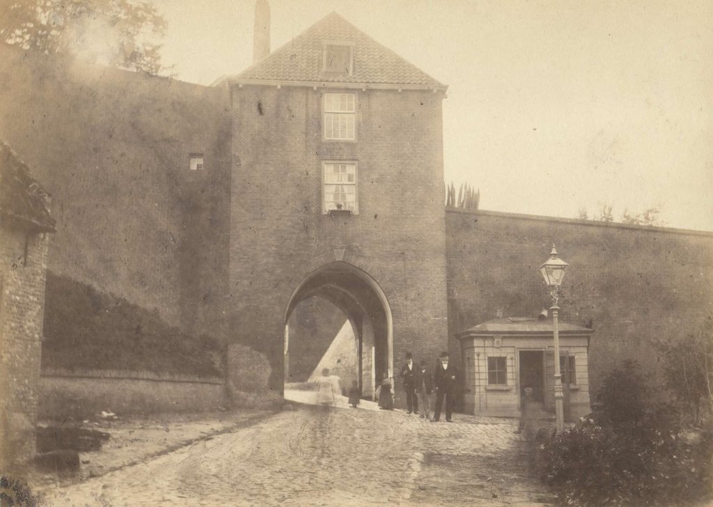 De Hunnerpoort werd ook wel Hoenderpoort of Ooypoort genoemd. Dit was een van de vier 'principaelpoorten'- voornaamste toegangswegen - van Nijmegen. Achter de poort leidde de Voerweg omhoog naar de Valkhofburcht. De naam Hunnerpoort verwijst mogelijk naar de Hunnen, die rond 360 op hun strooptochten ook Nijmegen zouden hebben aangedaan. De poort werd gebouwd tussen 1461 en 1466. Het bouwwerk bestond uit een bakstenen voorpoort en een hoofdpoort, totdat deze in 1579 werd aangepast aan de eisen van de veranderende belegeringstechnieken. Op deze foto uit 1874 is duidelijk te zien dat zich boven de dubbele poort een woning bevond, waar de poortwachter woonde. De Hunnerpoort werd in 1672 bij de belegering van de Fransen verwoest, vervolgens sober herbouwd en uiteindelijk als laatste van de Nijmeegse poorten afgebroken in 1882.