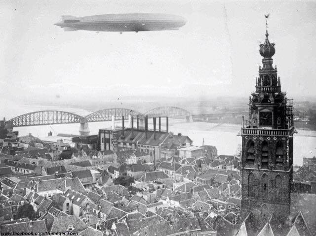 Een zeppelin boven Nijmegen in 1930 gezien vanaf de toren van de St. Augustinuskerk, in westelijke richting met de spoorbrug over de Waal.