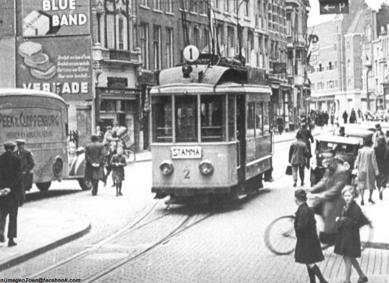 De Lange Burchtstraat omstreeks 1935. De kleine motorwagen 2 van Tramlijn 1 is zojuist vanaf het enkelspoor in de Korte Burchtstraat het dubbelspoor in de Lange Burchtstraat opgereden in de richting Hengstdal. Links op de foto prachtige reclame van 'Blue Band', 'Verkade' en op de bestelauto 'Peek & Cloppenburg.