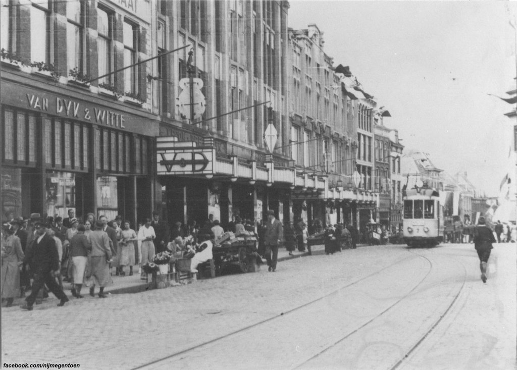 Een drukke winkeldag op de Grote Markt in hartje Nijmegen in de jaren '30. Links de Modewinkel van Van Dyk & Witte op de hoek met de Scheidemakersgas (links). In het midden warenhuis Vroom & Dreesmann. Rechts achter de tram de Stikke Hezelstraat.