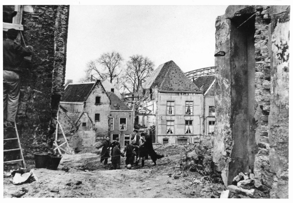 Voetballende jeugd in de oude Nijmeegse Benedenstad in de jaren 50. Deze foto is gemaakt vanaf de Muchterstraat in de richting van de Steenstraat. Rechts op achtergrond de achterzijde van de huizen aan de Waalkade. Links op de achtergrond het Brouwershuis