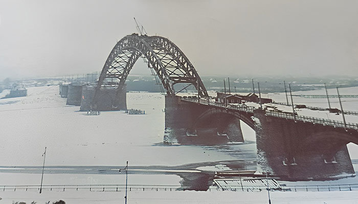 Nijmegen - Luchtfoto van de nog in aanbouw zijnde verkeersbrug bij Nijmegen omstreeks 1936